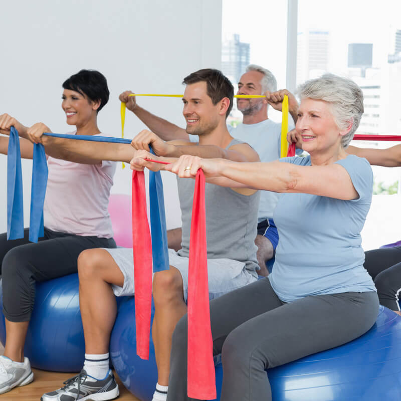 Mehrere Erwachsene trainieren mit dem Flexaband